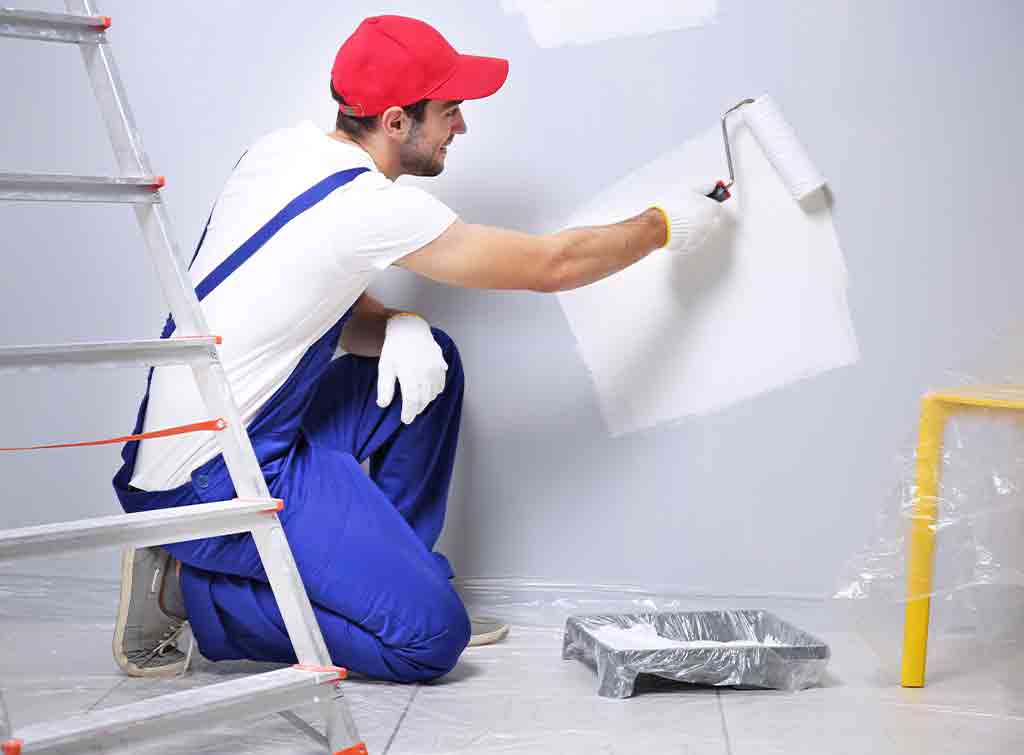 Painter decorating a wall with a roller